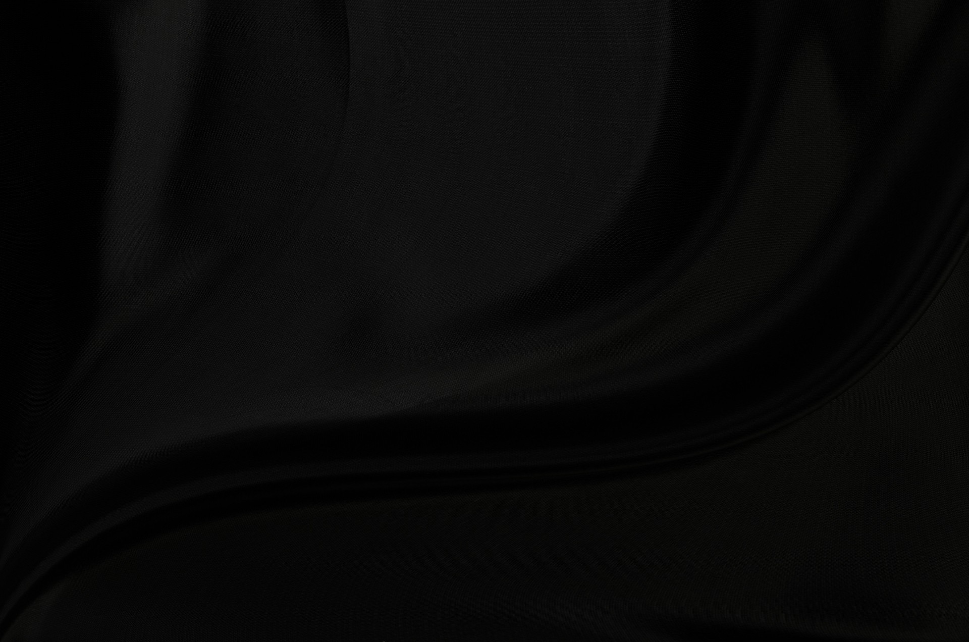 Black gray satin dark fabric texture luxurious shiny that is abstract silk cloth background with patterns soft waves blur beautiful.